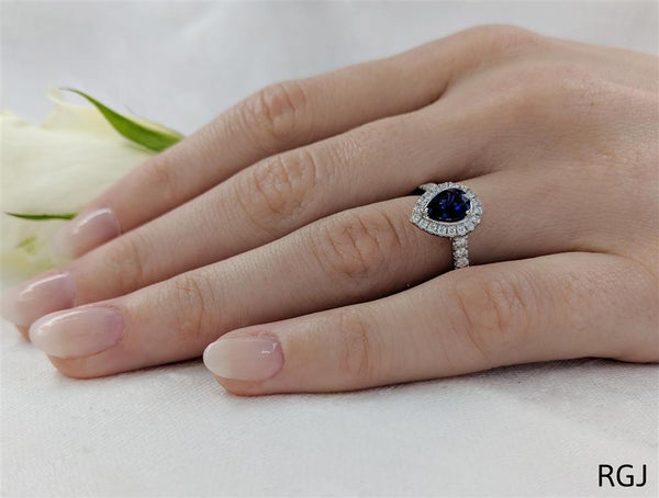 The Skye Platinum 0.76ct Pear Cut Blue Sapphire Ring With 0.33ct Diamond Halo And Diamond Set Shoulders