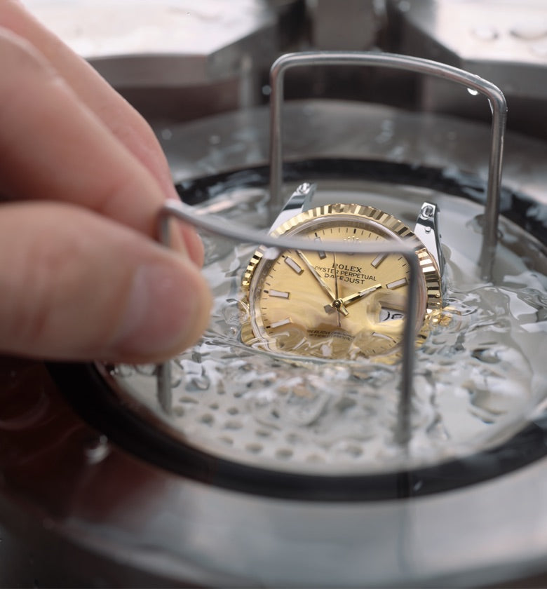 Close‑up view of a Rolex Datejust during a waterproofness test, showing the watch partially immersed as its sealing integrity is checked