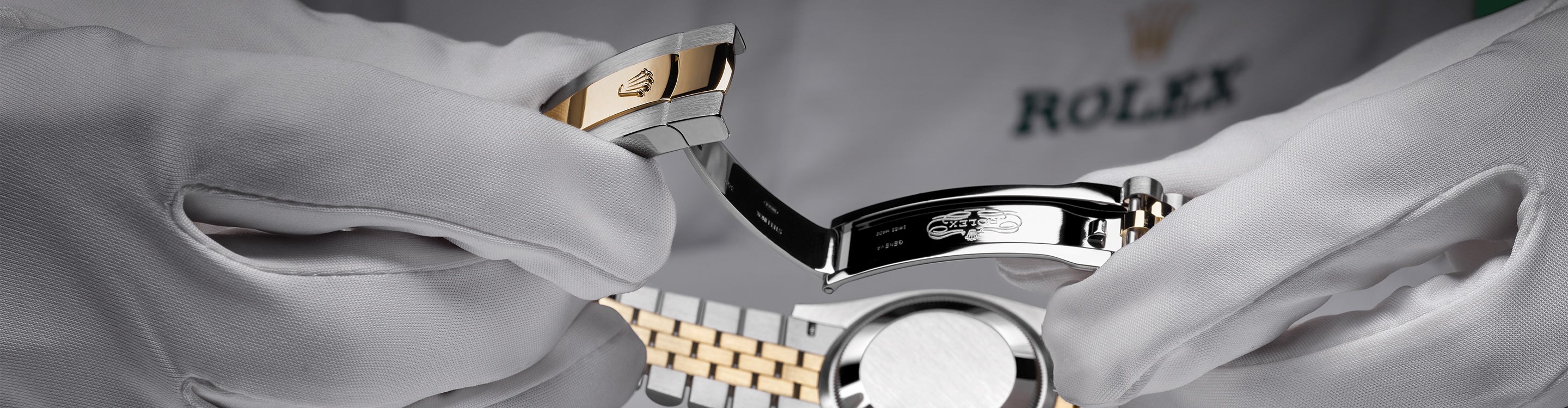 Close‑up image of a watchmaker holding a watch with both hands, carefully inspecting the clasp for proper function