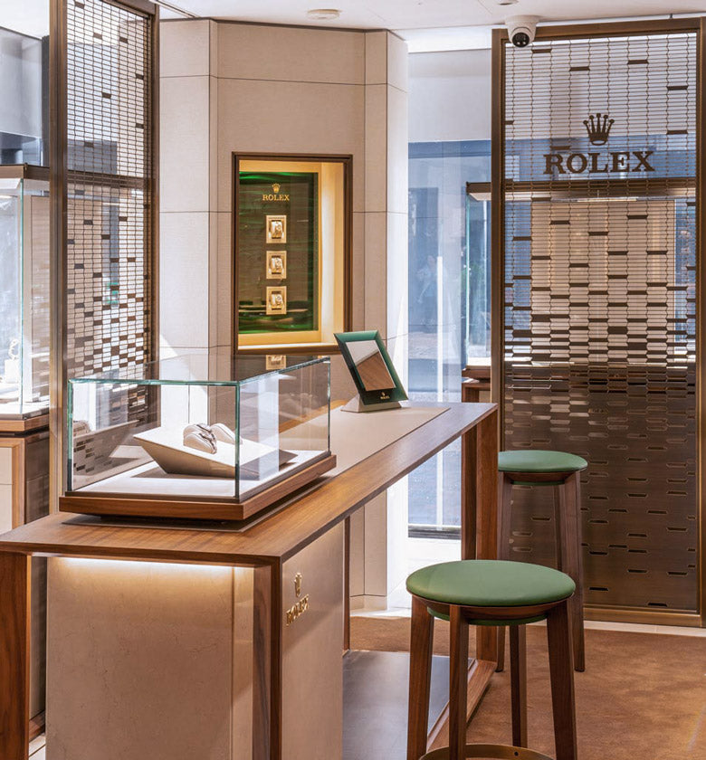 rolex at robert gatward our history, Rolex display case in a store with a chair and stool header banner for mobile