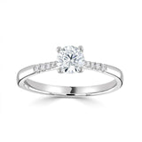 The Primula Platinum 0.30ct Round Brilliant Cut Diamond Solitaire Engagement Ring With 0.05ct Diamond Set Shoulders