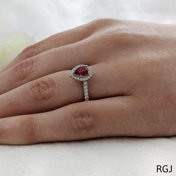 The Skye Platinum And 18ct Rose Gold 0.75ct Pear Cut Ruby Ring With 0.39ct Diamond Halo And Diamond Set Shoulders