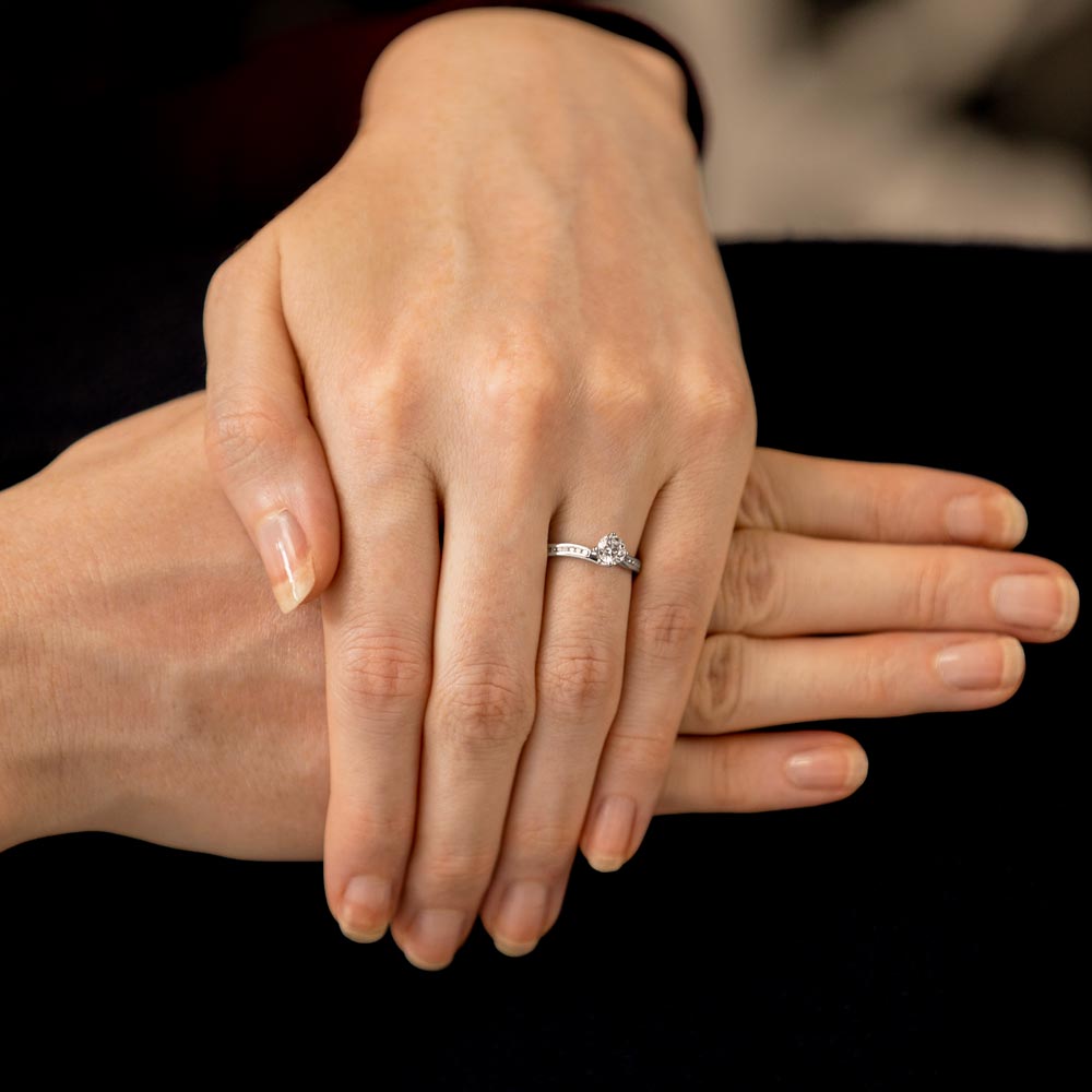 The Rose Platinum 0.50ct Round Brilliant Cut Diamond Solitaire Engagement Ring With 0.10ct Channel Set Diamond Shoulders