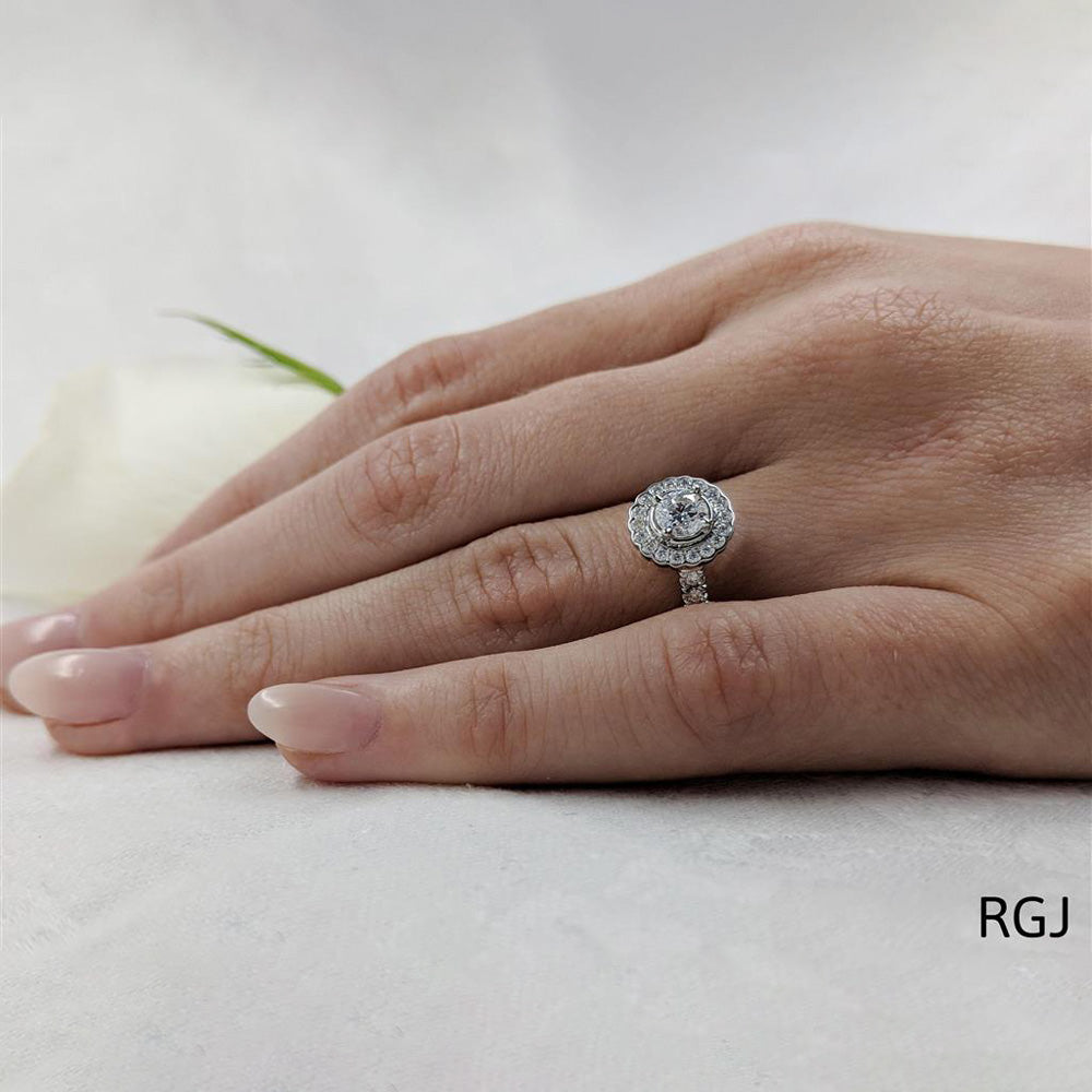 The Faroe Platinum 0.40ct Round Brilliant Cut Diamond Engagement Ring With 0.30ct Scalloped Diamond Halo And Diamond Set Shoulders