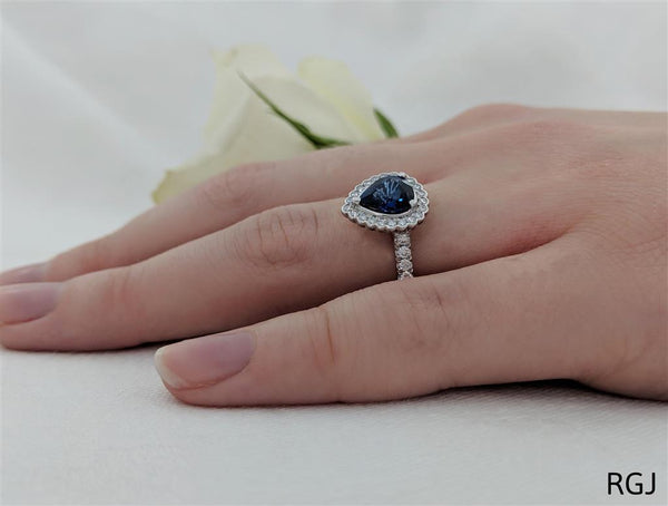 The Faroe Platinum 1.10ct Pear Cut Blue Sapphire Ring With 0.41ct Diamond Halo And Diamond Set Shoulders