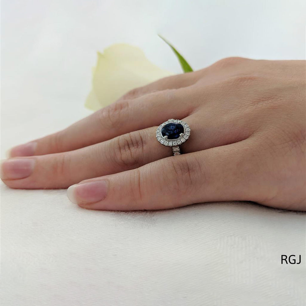 The Skye Platinum 0.74ct Oval Cut Blue Sapphire Ring With 0.35ct Diamond Halo And Diamond Set Shoulders