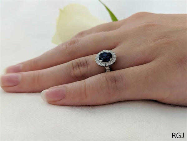The Skye Platinum 0.74ct Oval Cut Blue Sapphire Ring With 0.35ct Diamond Halo And Diamond Set Shoulders