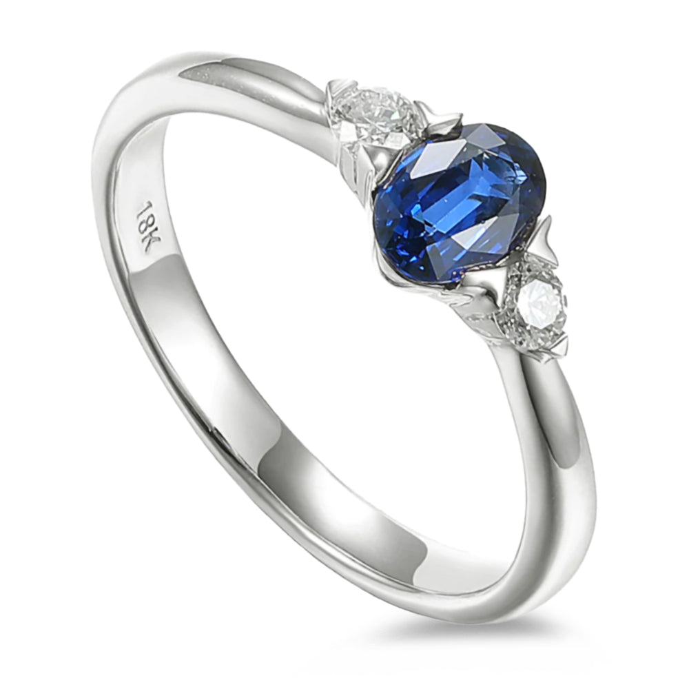 Platinum 0.62ct Oval Cut Blue Sapphire And 0.12ct Round Brilliant Cut Diamond Three Stone Ring