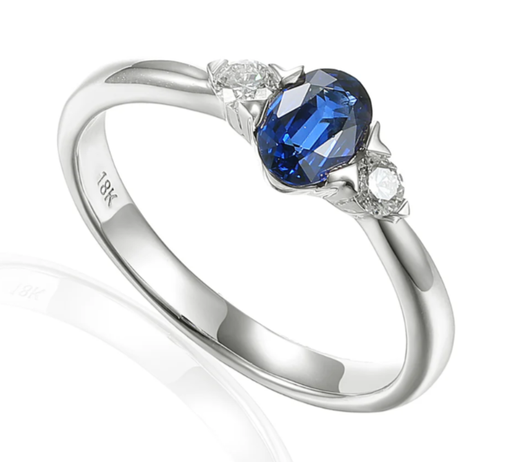 Platinum 0.62ct Oval Cut Blue Sapphire And 0.12ct Round Brilliant Cut Diamond Three Stone Ring