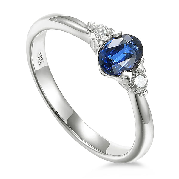 18ct White Gold 0.73ct Oval Cut Blue Sapphire And 0.13ct Round Brilliant Cut Diamond Three Stone Ring