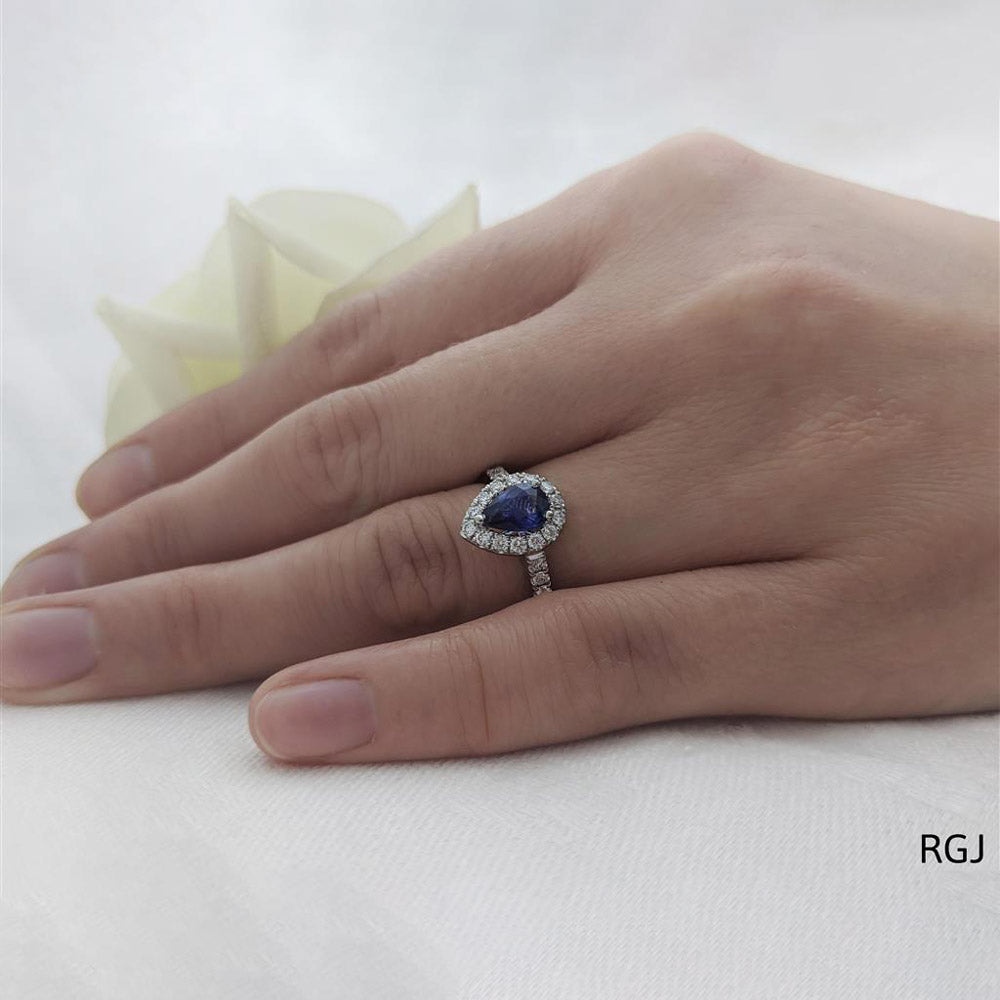 The Evie Platinum 0.77ct Pear Cut Blue Sapphire Ring With 0.44ct Diamond Halo And Diamond Set Shoulders