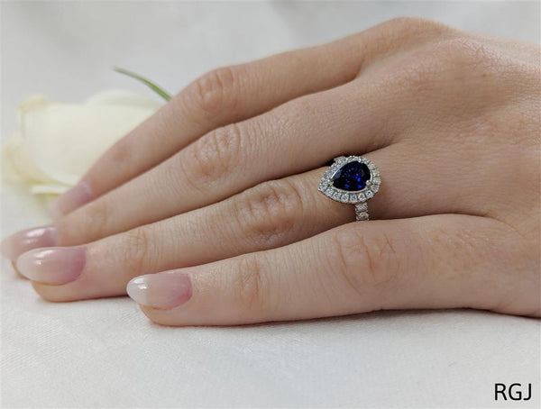 The Skye Platinum 1.01ct Pear Cut Blue Sapphire Ring With 0.34ct Diamond Halo And Diamond Set Shoulders