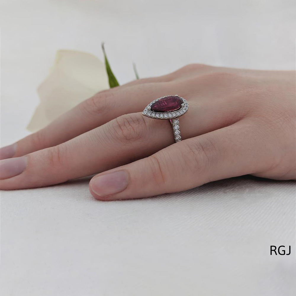 The Skye Platinum 1.92ct Pear Cut Ruby Ring With 0.44ct Diamond Halo And Diamond Set Shoulders