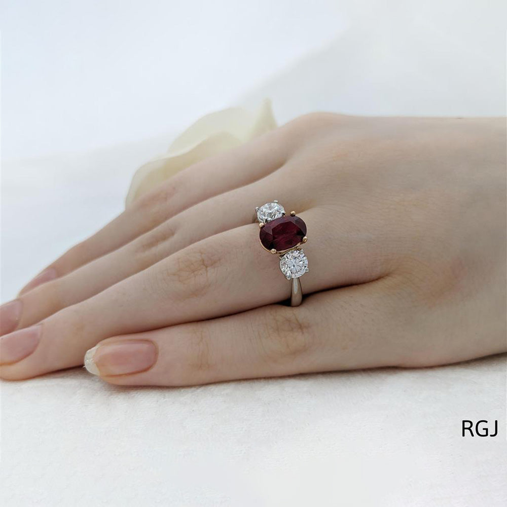 The Florentina Iconic Platinum 2.04ct Oval Cut Ruby And 1.01ct Round Brilliant Cut Diamond Three Stone Ring With 0.08ct Diamond Detailing