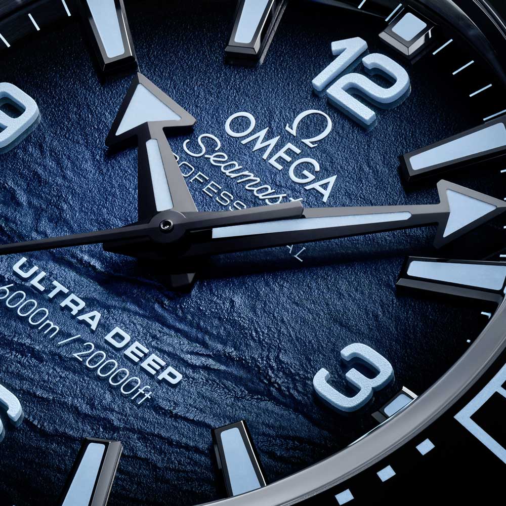 omega seamaster planet ocean 6000m blue dial o-megasteel on o-megasteel bracelet deep diving automatic gents watch showing its dial closeup