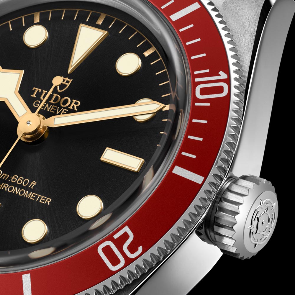 tudor black bay 41mm black dial steel on steel bracelet automatic watch burgundy bezel closeup