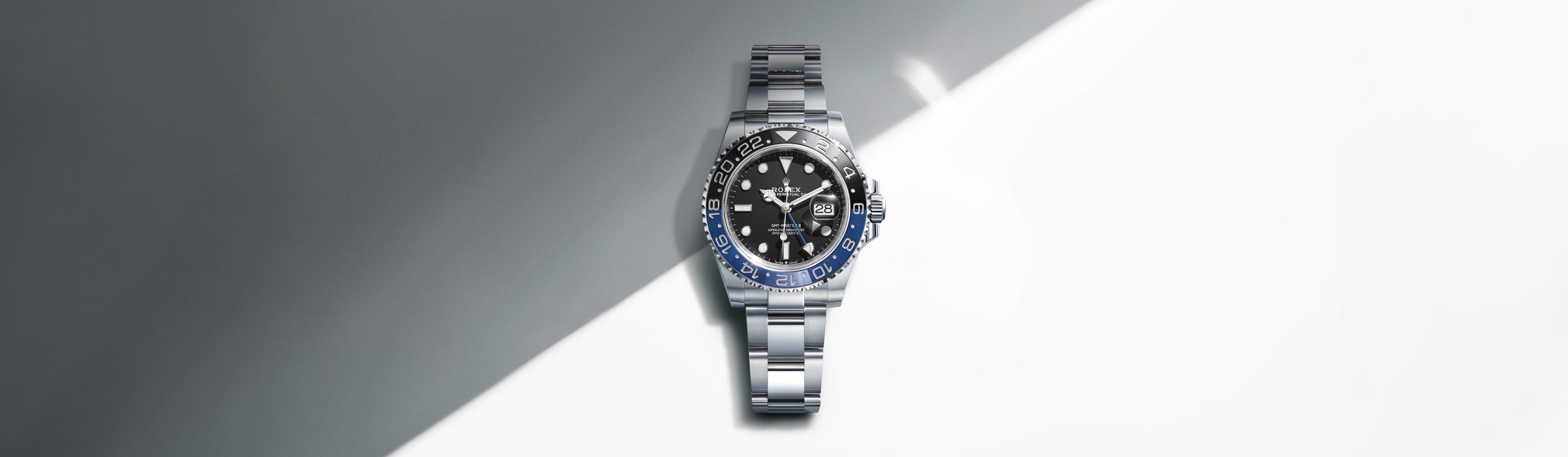 Rolex GMT‑Master II m126710BLNR‑0003 shown as the cover image, set against a diagonally divided dark‑grey and white backdrop representing night and day, echoing the watch’s dual‑time functionality