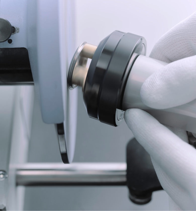 Close‑up image showing a domed bezel undergoing polishing as part of the watch servicing process, with tools visible