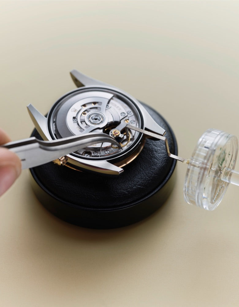 Close‑up image of a watchmaker carefully working on a watch movement
