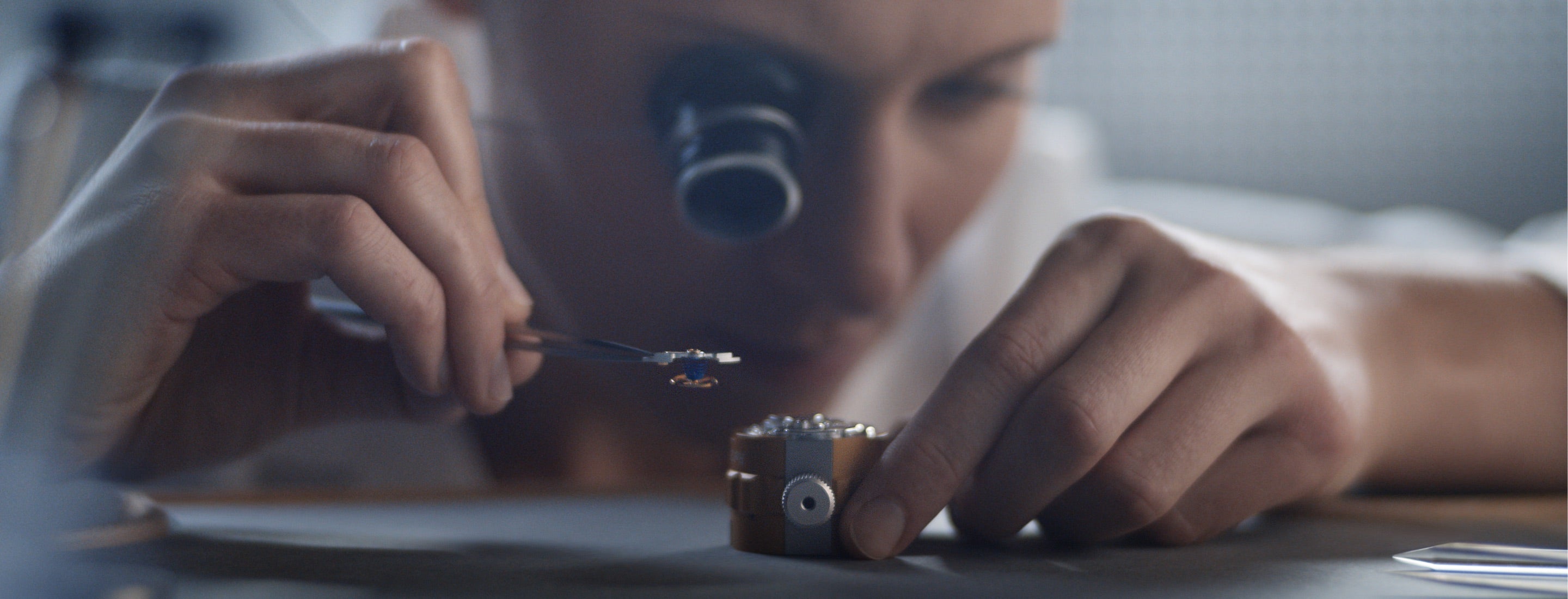 Rolex watchmaking landscape banner image showing watchmaker assembling the movement
