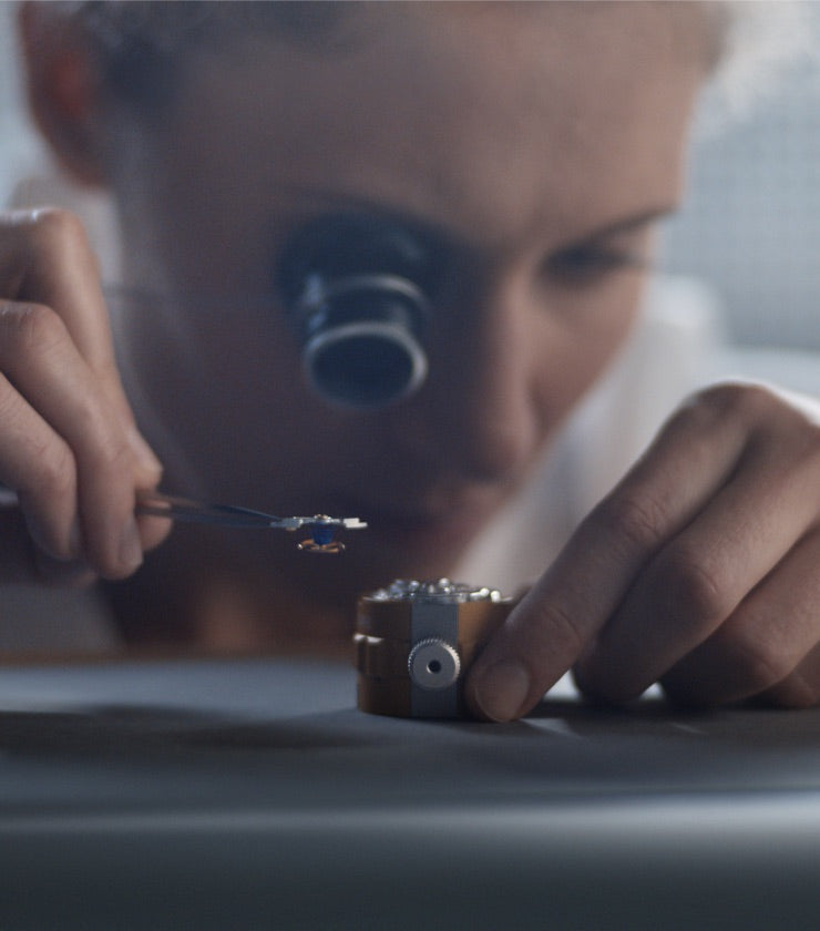 Rolex watchmaking portrait banner image showing watchmaker assembling the movement