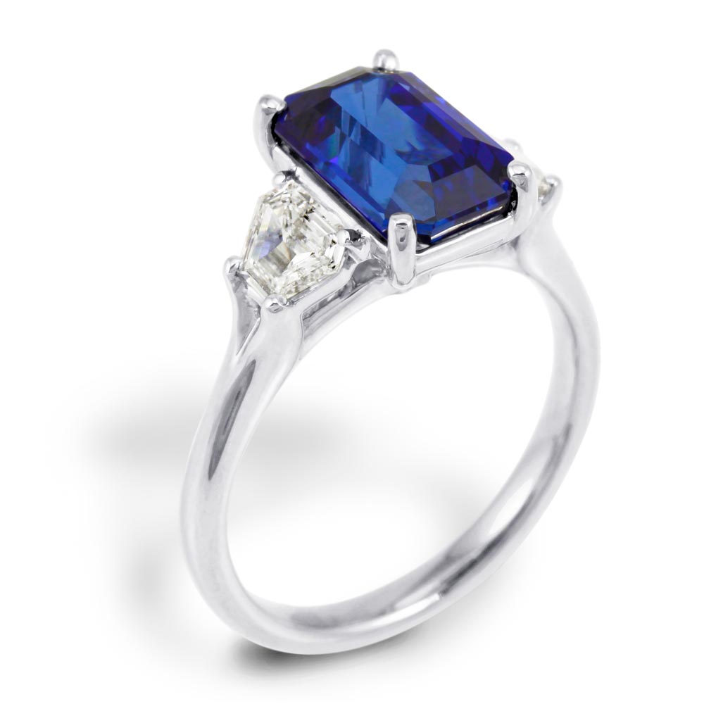 The Florentine Platinum 3.32ct Emerald Cut Blue Sapphire and 0.63ct Diamond Three Stone Engagement Ring