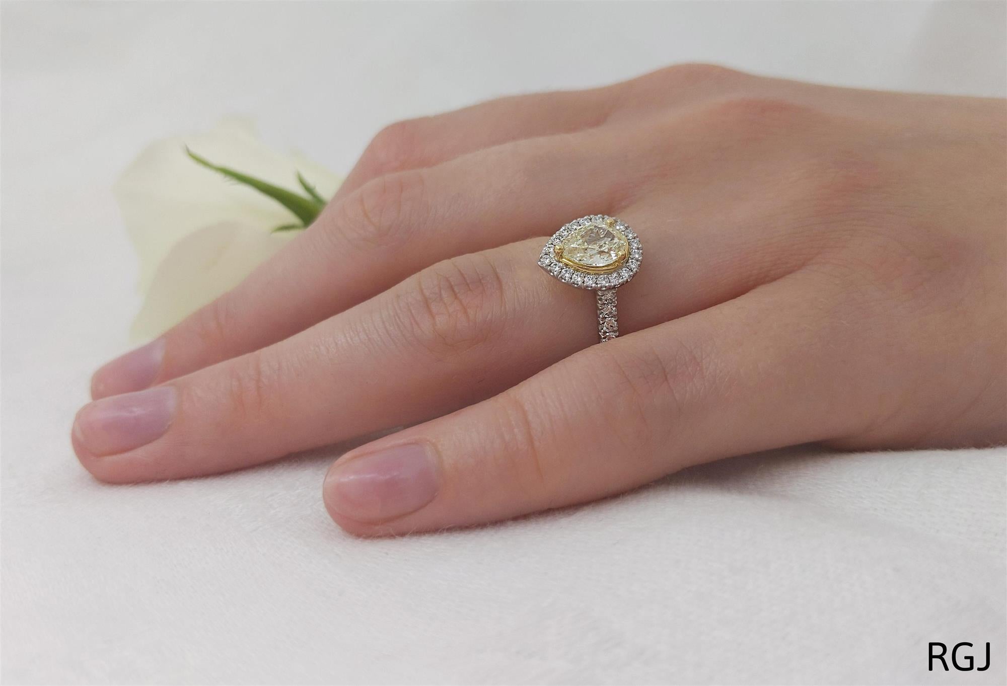 the skye platinum and 18ct yellow gold 0.57ct pear cut yellow diamond ring with 0.33ct diamond halo and diamond set shoulders model hand shot