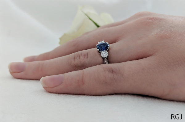 the memoire platinum 0.98ct oval cut blue sapphire and 0.55ct diamond three stone engagement ring with diamond set shoulders model shot