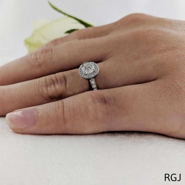 The Dulcina Platinum Round Brilliant Cut Diamond Engagement Ring With Diamond Halo And Diamond Set Shoulders